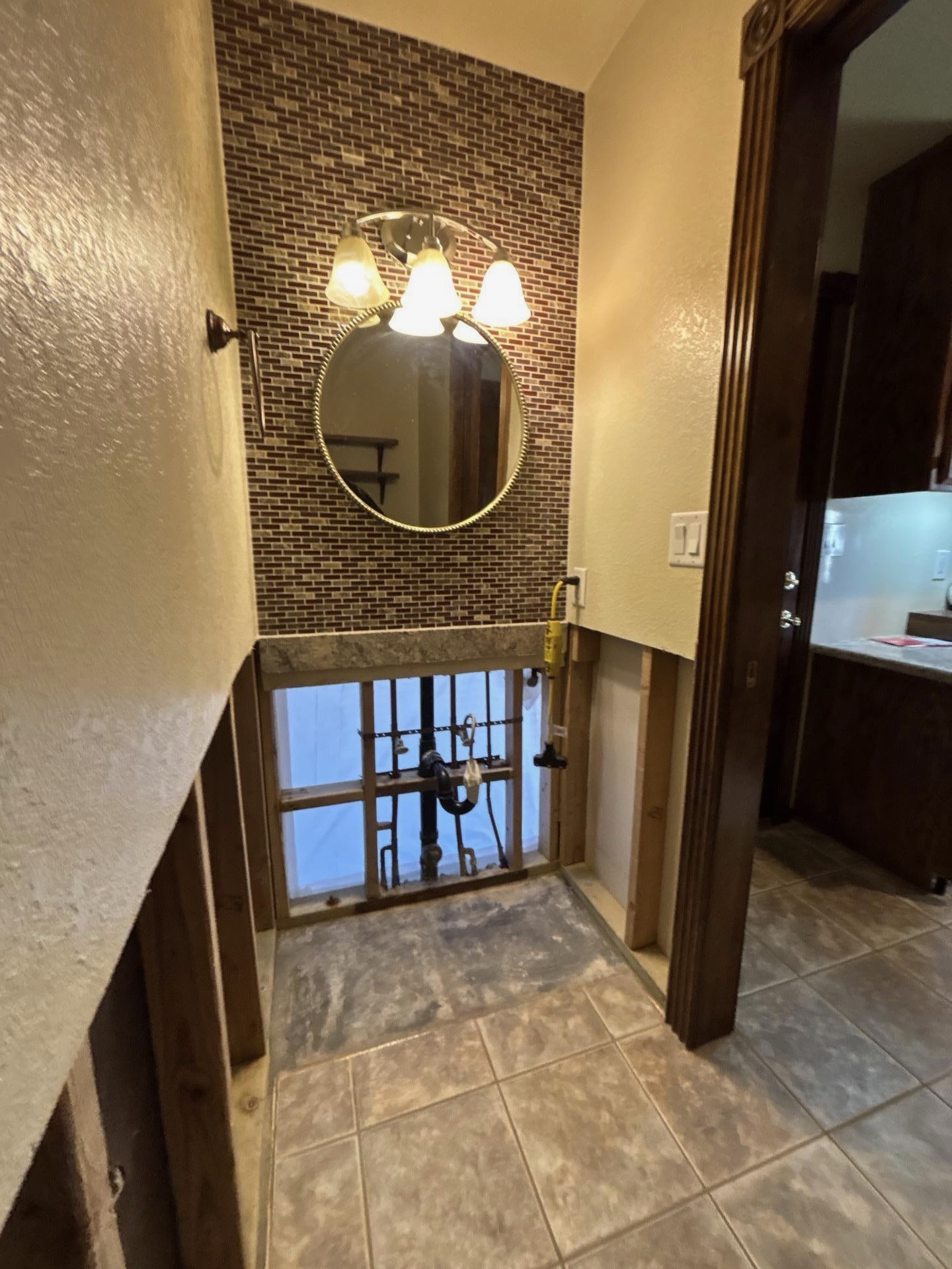 Bathroom water damage — flood cuts and vanity demo exposing plumbing, Bakersfield CA